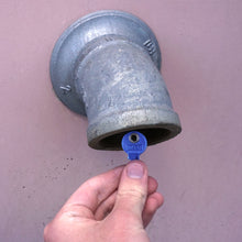 Load image into Gallery viewer, 50693 Magnetic Key, M1-69 Blue - Hand Holding Blue Magnetic Key Next to a Drain Pipe