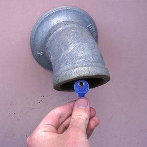 50693 Magnetic Key, M1-69 Blue - Hand Holding Blue Magnetic Key Next to a Drain Pipe