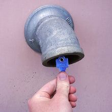 Load image into Gallery viewer, 50773 Magnetic Key, WR5-67 Blue - Hand Holding a Blue Magnetic Key Next to a Drain Pipe
