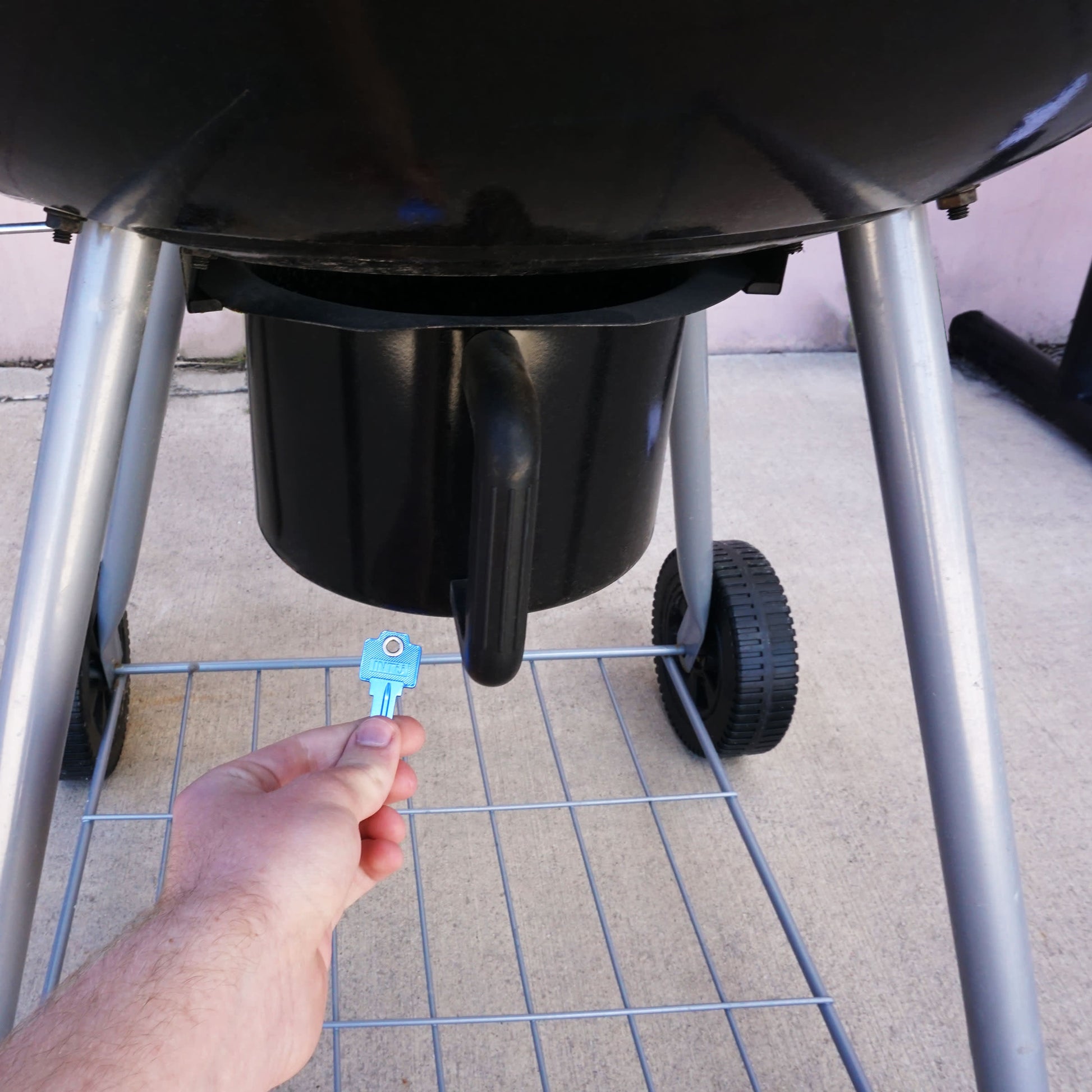 Load image into Gallery viewer, 50773 Magnetic Key, WR5-67 Blue - Hand Holding Blue Magnetic Key Beneath a Barbeque Grill