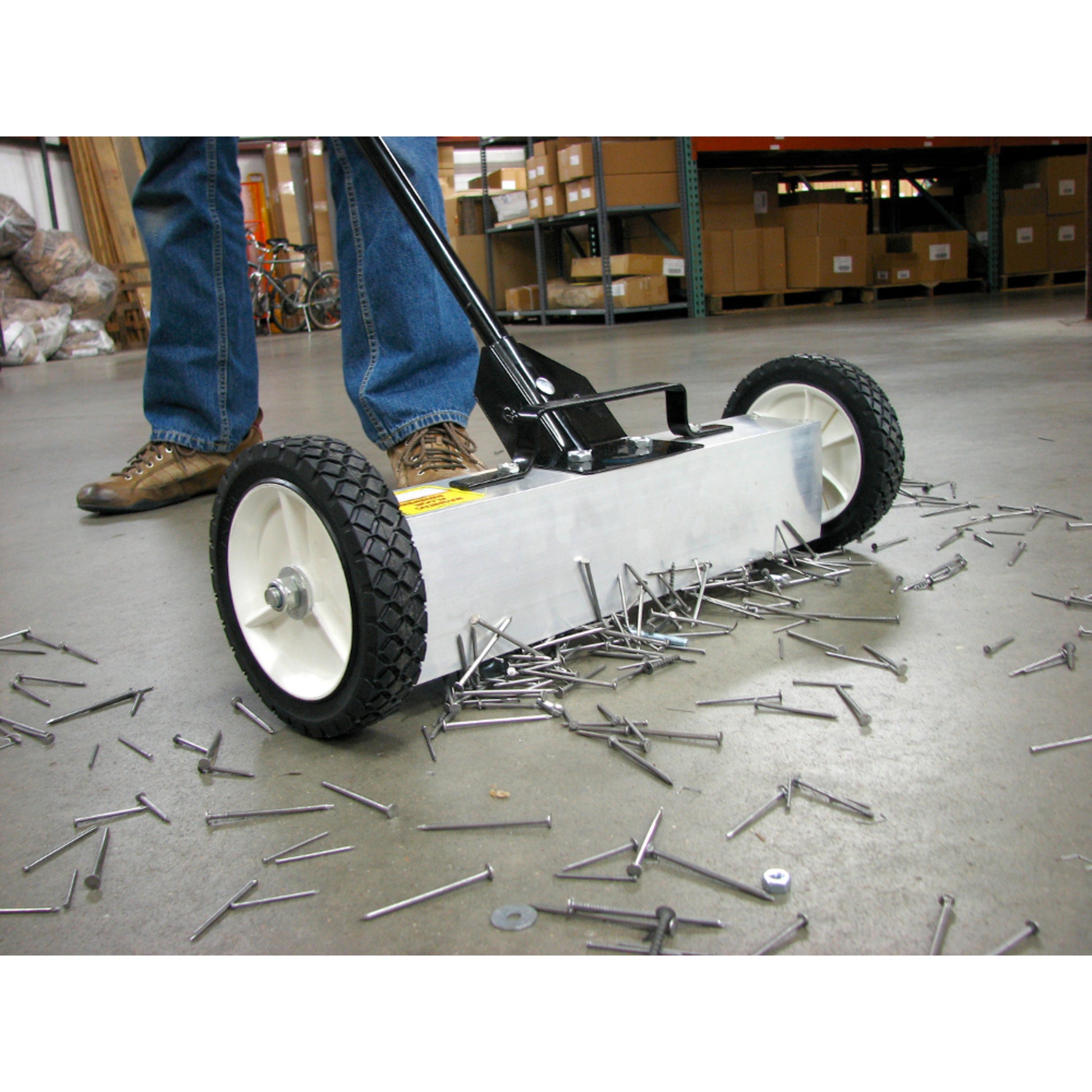 Load image into Gallery viewer, 07543 Magnetic Floor Sweeper with Quick Release - Sweeper picking up metal debris from warehouse floor