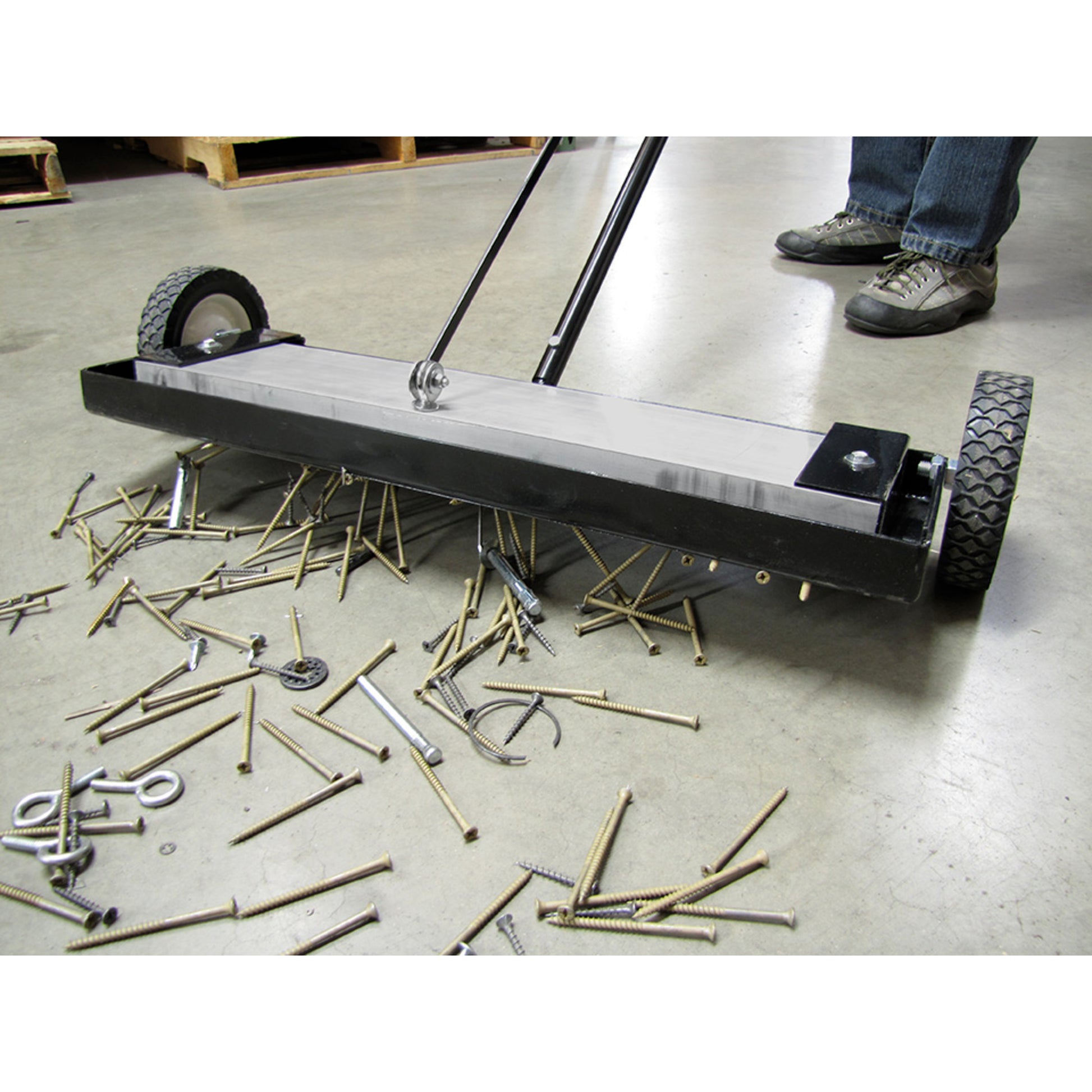Load image into Gallery viewer, MFSM24RX Magnetic Floor Sweeper with Quick Release - Sweeper picking up metal debris on warehouse floor